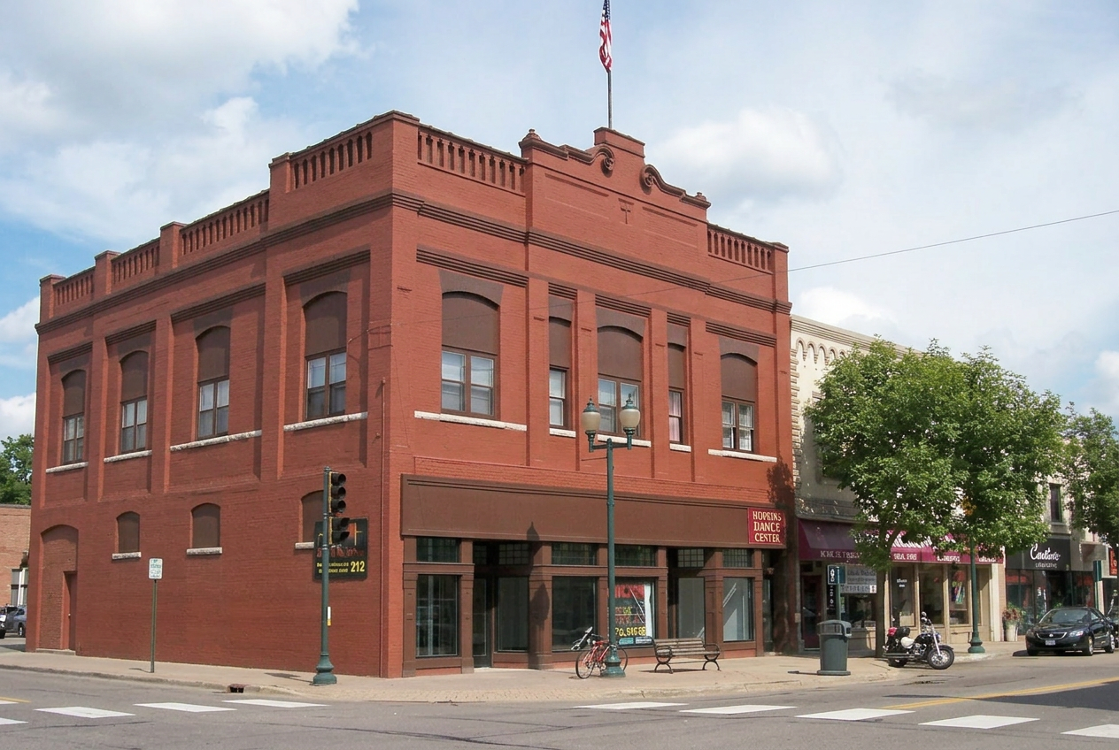 Historic brick storefronts along Mainstreet in downtown Hopkins on a summer afternoon